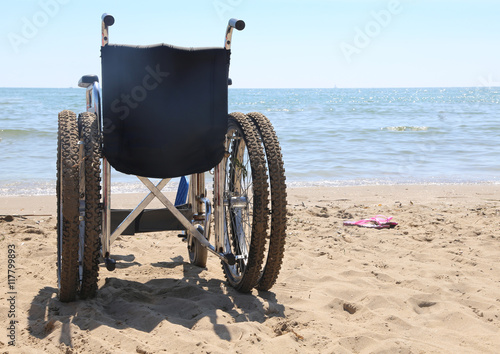 wheelchair on the beach by the sea photo