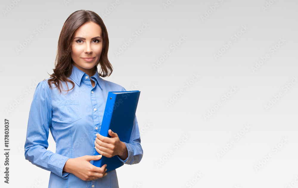 Businesswoman with blue folder, against grey Businesswoman with blue folder, against grey