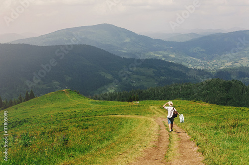 stylish hipster traveler man holding map and walking at mountai