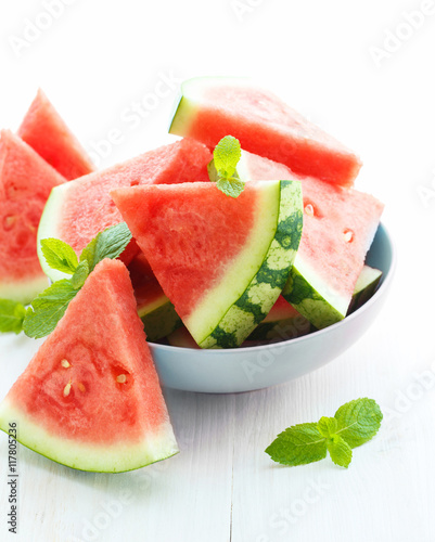 Triangular slices of fresh watermelon on white wooden background