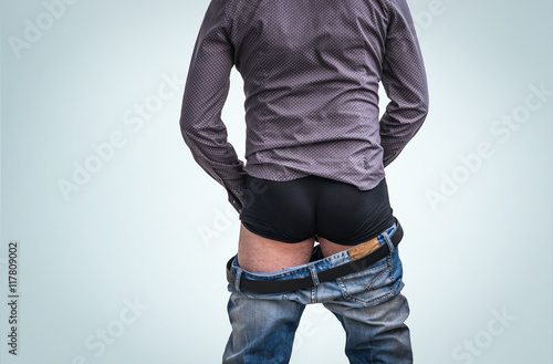 Standing man has undress jeans and peeing photo