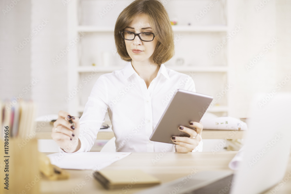 Woman using tablet and doing paperwork Woman using tablet and doing paperwork