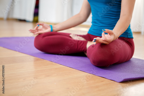Young woman doing yoga at home, model in lotus position