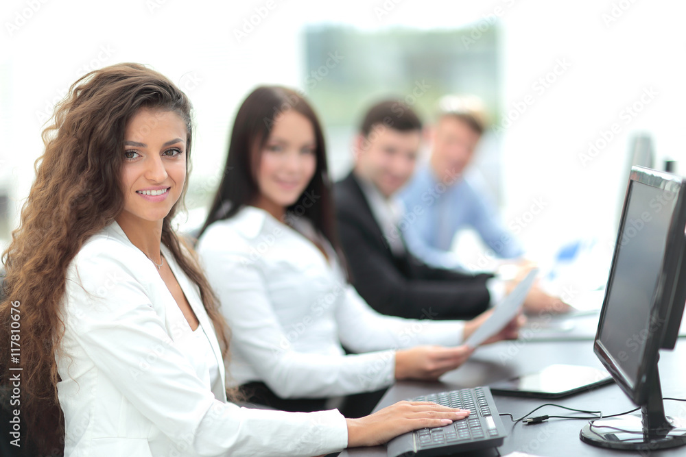 Young businesswoman working in an office using computer with co Young businesswoman working in an office using computer with co