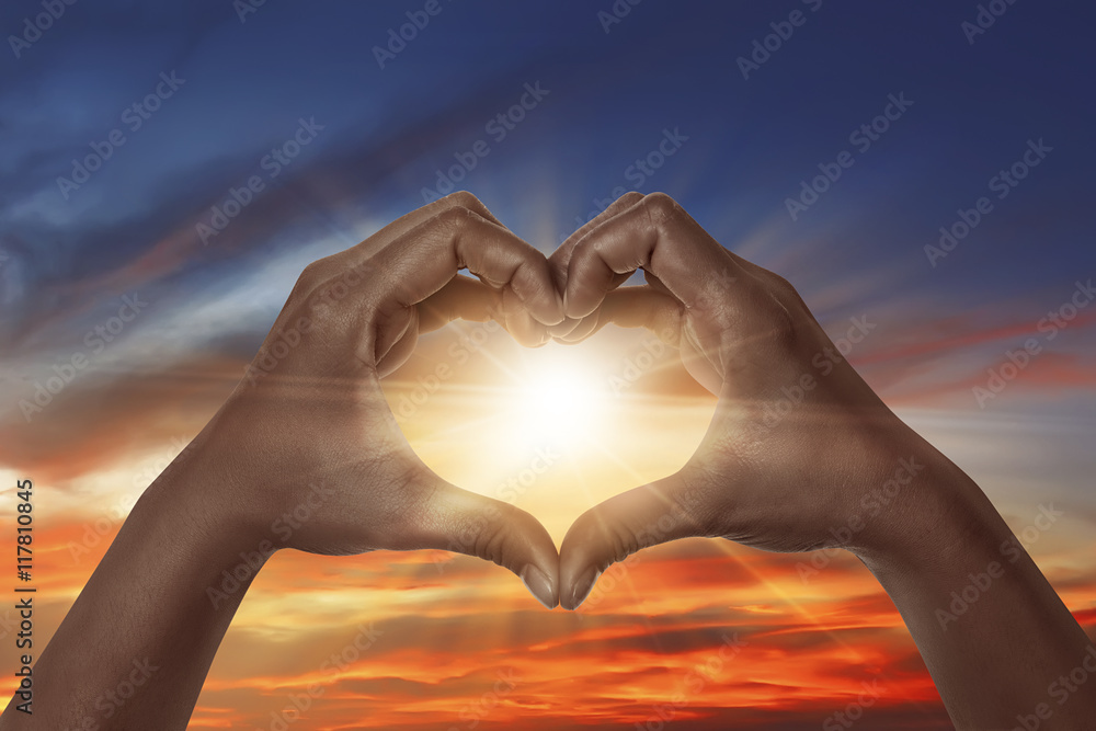 Fototapeta premium Heart shaped hand with sunrise