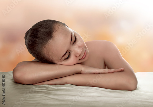 Asian woman have relax time. He have natural skin and look relax with orange background