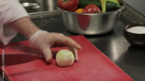 Chef chopping onion into half rings, close up photo