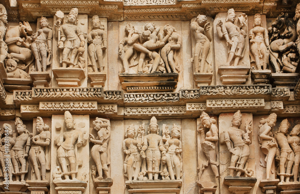 Stone relief with sexual life of ancient people on wall of Khajuraho temple, India. UNESCO Heritage site