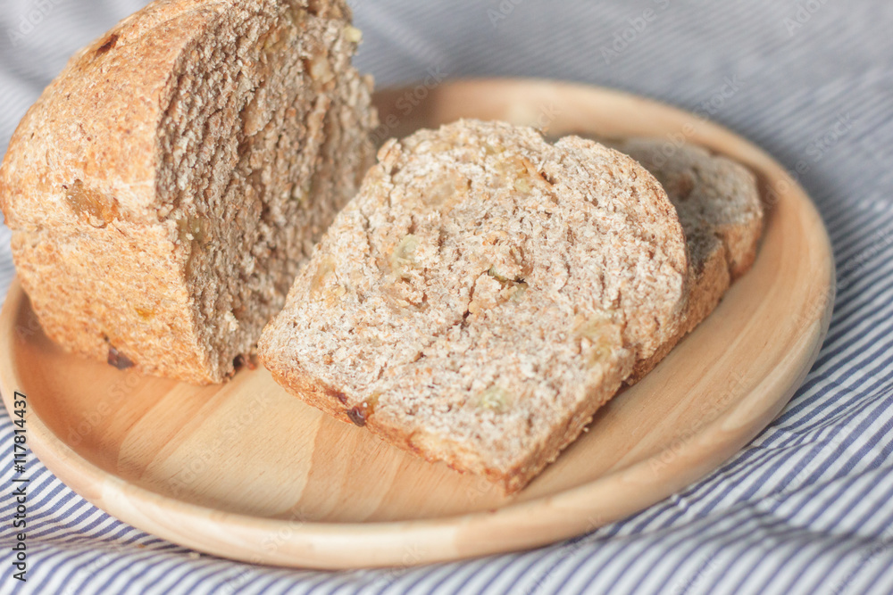 whole wheat bread is sliced on the wooden plate