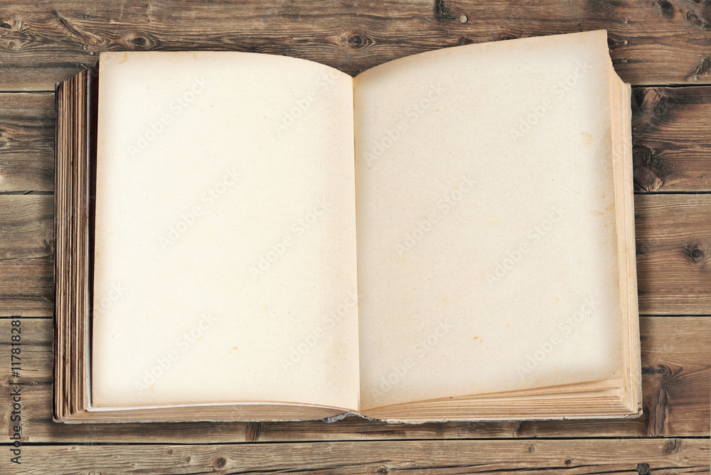 Obraz premium geöffnetes altes Buch auf rustikalem Holz-Hintergrund
