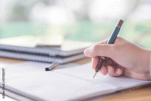 female hands with pen writing on notebook coffee cafe