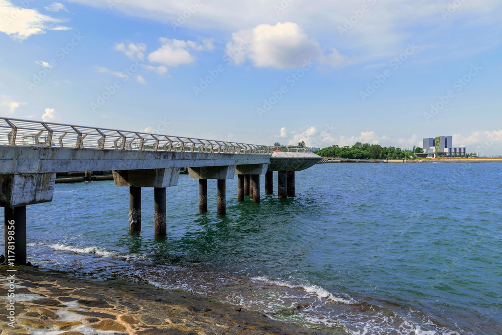 Concrete bridge pier extending into the sea.