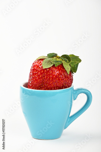 Fototapeta Naklejka Na Ścianę i Meble -  Big strawberry in blue espresso cup over white
