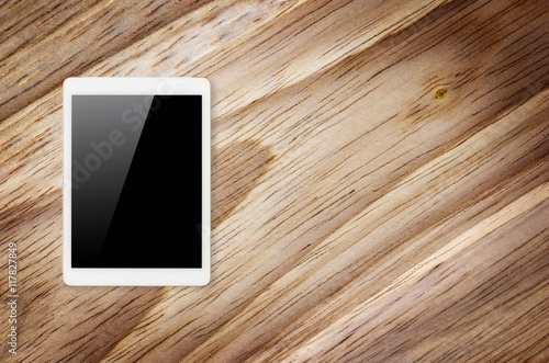 Digital tablet on wooden background.