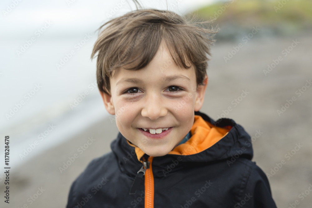 boy enjoying the rain and having fun outside on the beach a gray rainy boy enjoying the rain and having fun outside on the beach a gray rainy