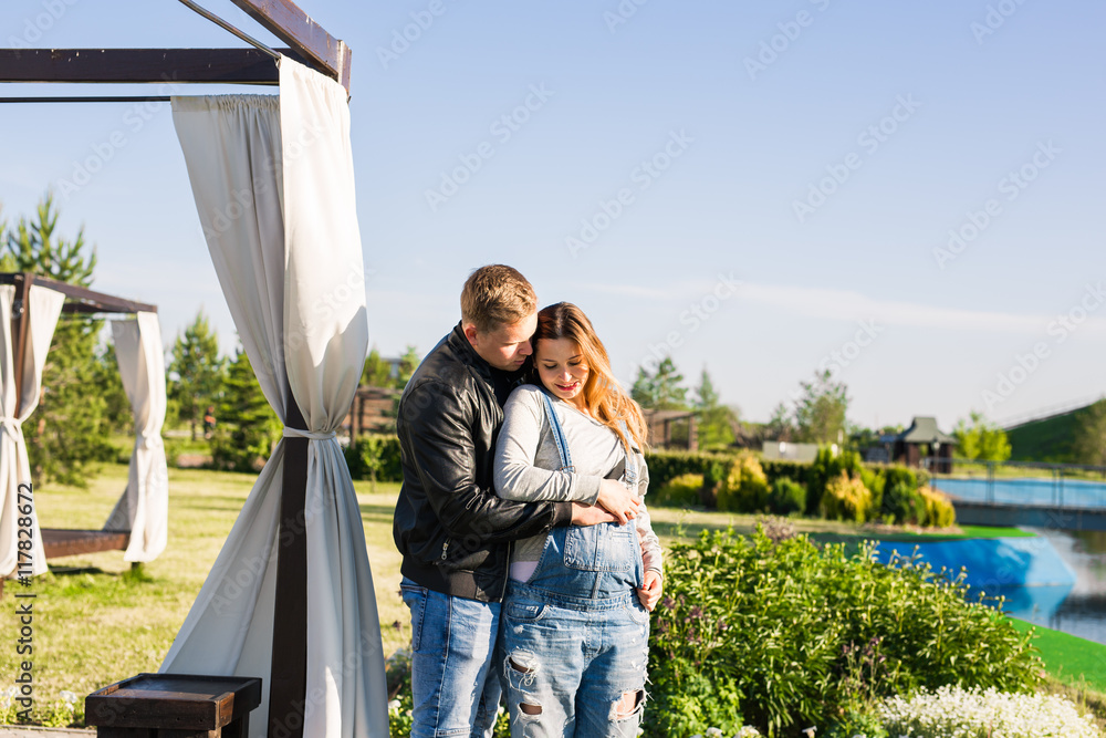 Happy couple awaiting baby, cute pregnant woman with husband enjoying spring weather, love concept