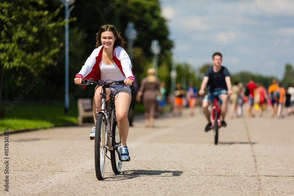 Urban bicycle - teenage girl and boy cycling 