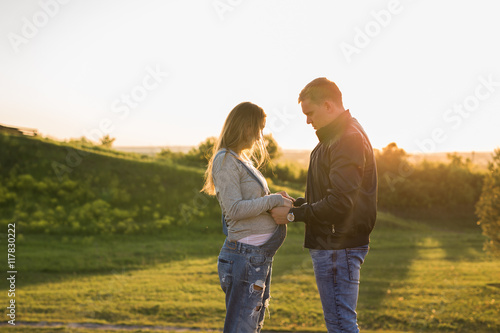Happy couple awaiting baby  cute pregnant woman with husband enjoying autumn weather  love concept