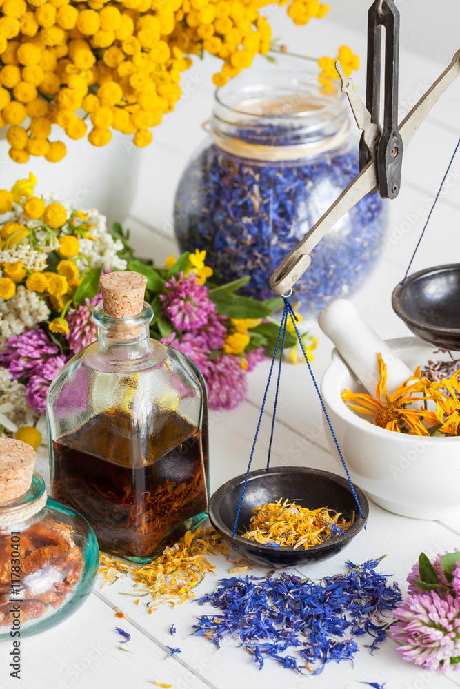 Bottles of tincture, mortar, jar of healthy herbs and scales on Bottles of tincture, mortar, jar of healthy herbs and scales on