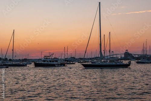 Sunset on boat deck. Sunset on ocean. Boats on bay. Bridge. Sunset clouds background. Ocean waves. Ocean sunset. Boats in water. Natures beauty. 