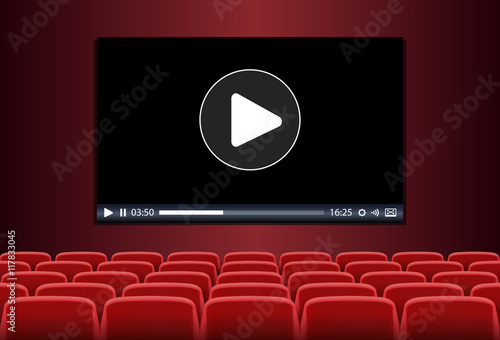 Rows of red seats in front of multimedia playing on a screen