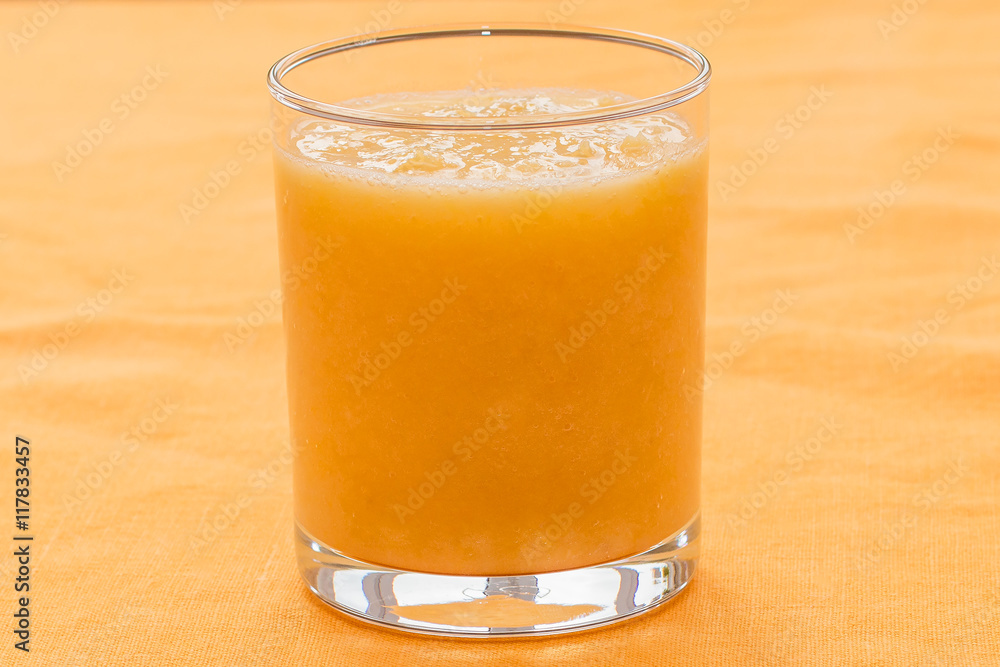 Orange smoothie on orange background Orange smoothie on orange background