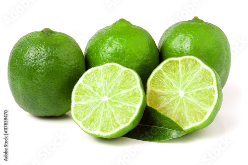 three limes with halves and leaf isolated on white background
