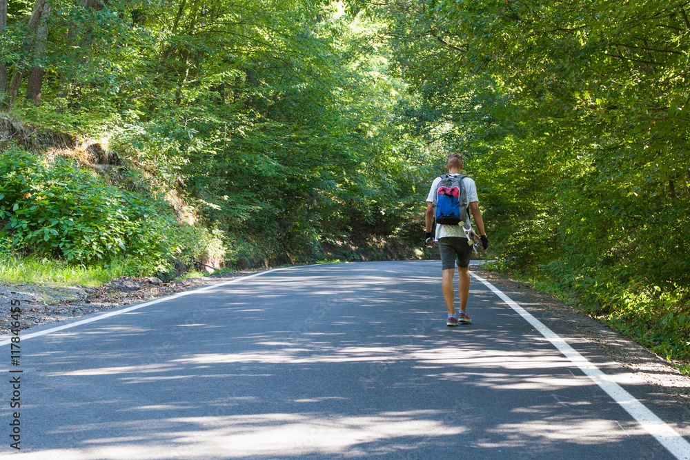 Fototapeta premium Young men on the road with longboard