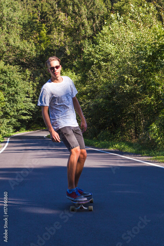 Young men on the longboard on road