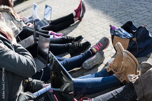 jugendliche sitzen am laptop auf dem Schulhof