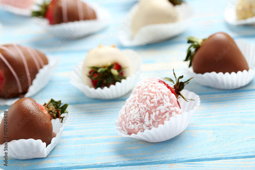 Strawberries covered in chocolate on a blue wooden table Strawberries covered in chocolate on a blue wooden table