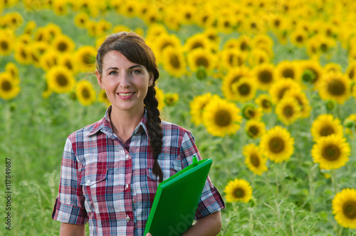 Beautiful young woman standing in sunflower field