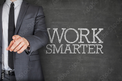 Foto Work smarter on blackboard with businessman