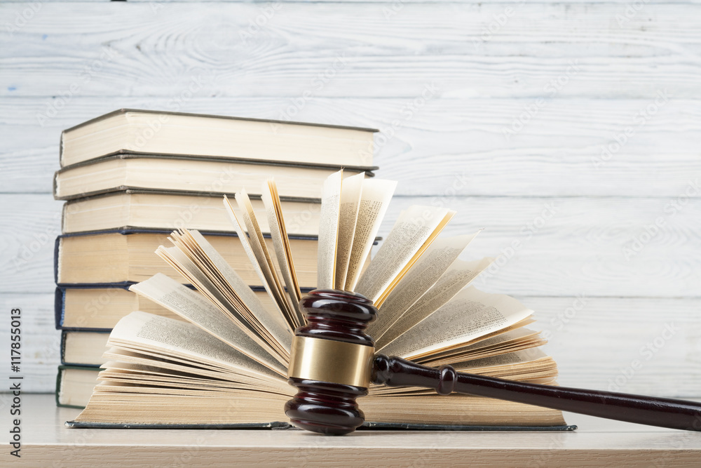 Law concept - Book with wooden judges gavel on table in a courtroom or enforcement office. Law concept - Book with wooden judges gavel on table in a courtroom or enforcement office.