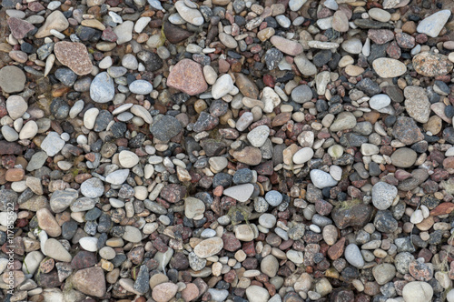 Different color pebbles background pattern on the sand
