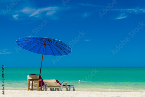 Fototapeta Naklejka Na Ścianę i Meble -  Beach chairs on the sand beach with cloudy blue sky