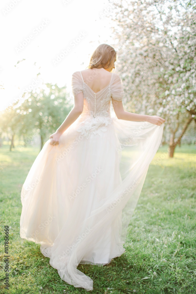 Young beautiful bride portrait in park with flowers