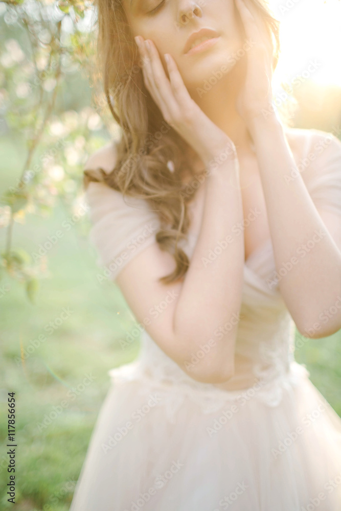Naklejka premium Young beautiful bride portrait in park with flowers