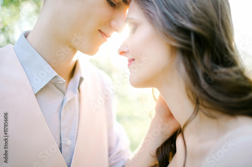Portrait of beautiful young newlyweds outdoors over sunlight