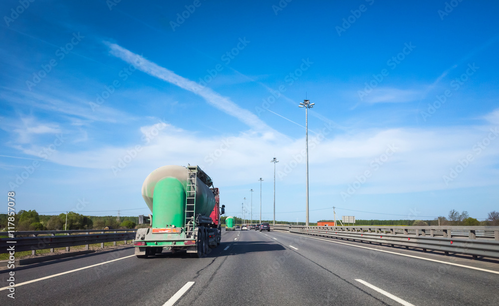 Green cargo tanker truck goes on asphalt highway