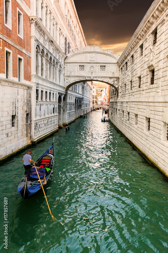 Bridge of Sighs in Venice at sunset with a floating past gondola. Travel Italy.