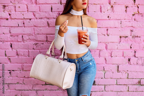 Fashionable woman with big handbag near pink street wall