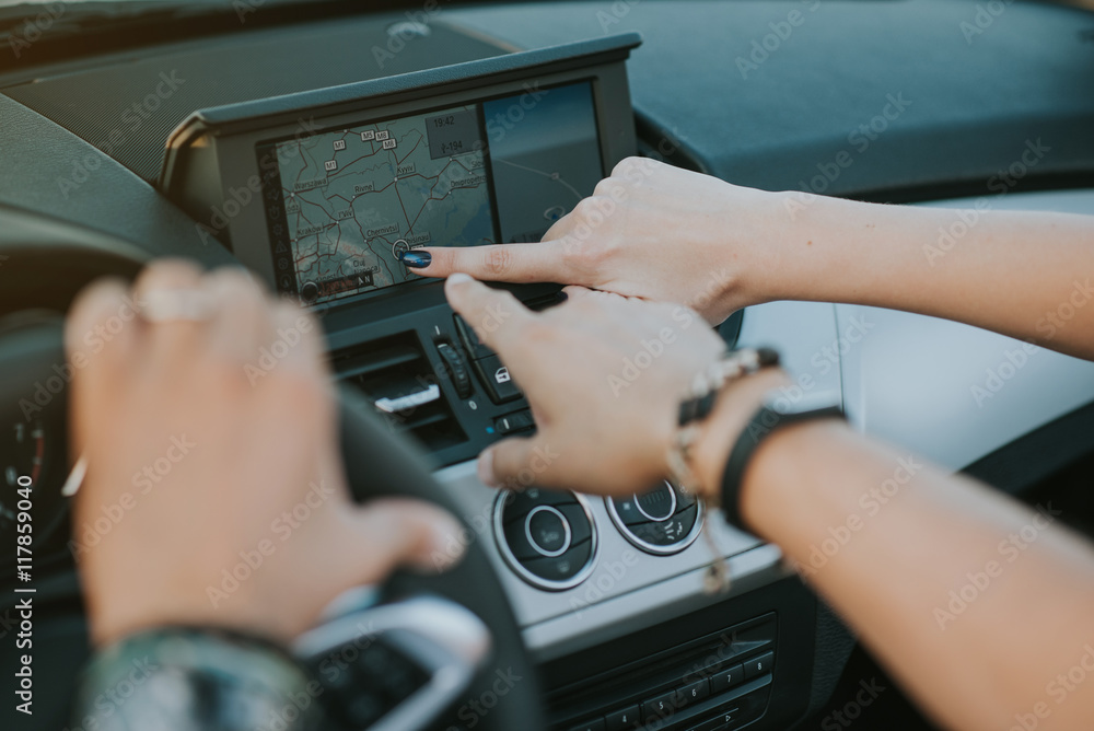 fingers pointing to the car gps system 