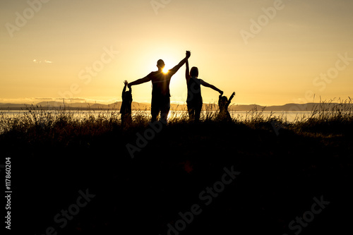 family of four at sunset shadow black backlit