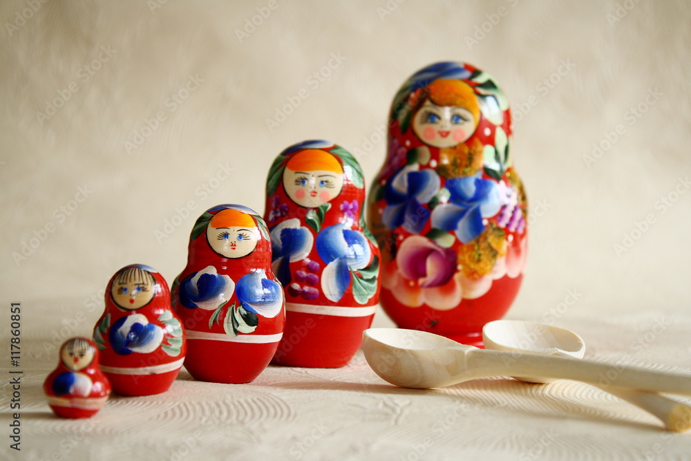 Row Russian Matryoshkas and two wooden spoons