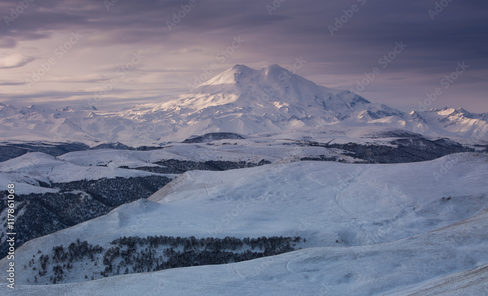 Mountain Elbrus in the winter in the rays of the dawn sun.