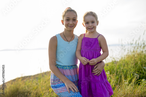 sisters at the beach on sunset photo