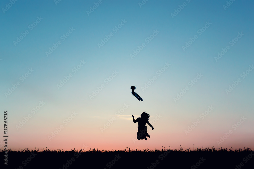 Silhouette of a beautiful girl jumping over sunset Silhouette of a beautiful girl jumping over sunset