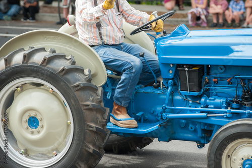 Vintage blue Ford tractor with big wheels and farmer. photo