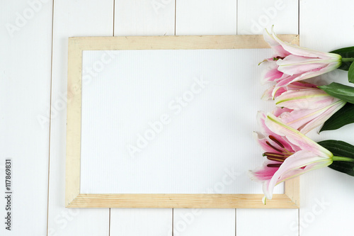 Fototapeta Naklejka Na Ścianę i Meble -  Vintage lily flower on retro whiteboard on white wood background
